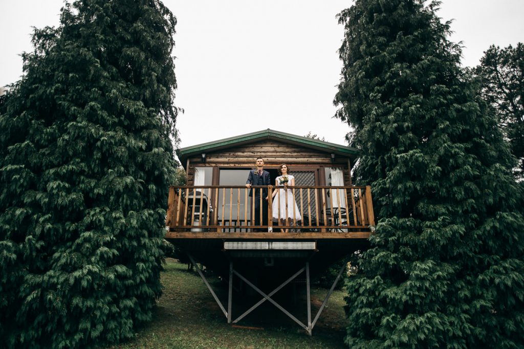 Bride and groom standing on the balcony of a log cabin at their Bilpin wedding