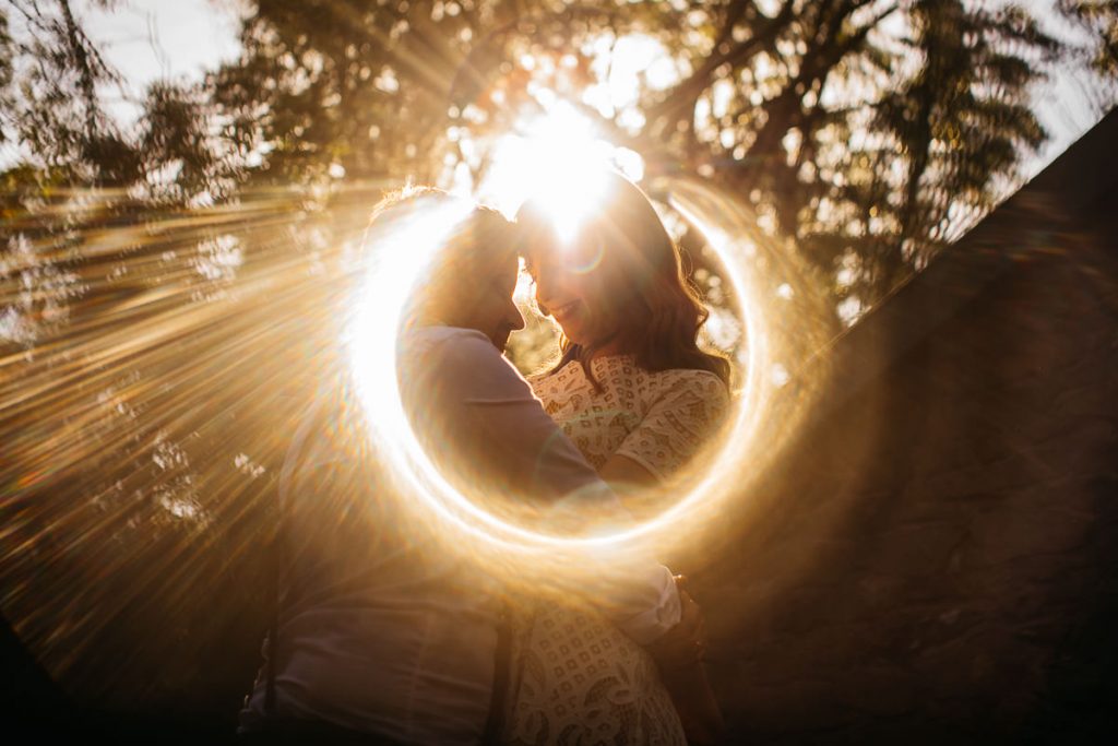Creative wedding photograph of sunchine circling the bride grrom