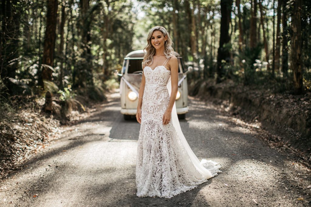 Bundanon Wedding; South Coast Wedding Photographer; Bride stands smiling on a forest road in front of her decorated Volkswagon minivan in Bundanon