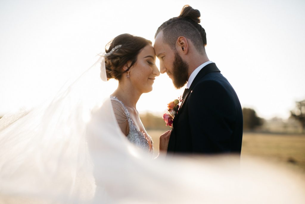 Burnham Grove Wedding photography; Bride and groom lovingly touch foreheads wrapped in bride's veil