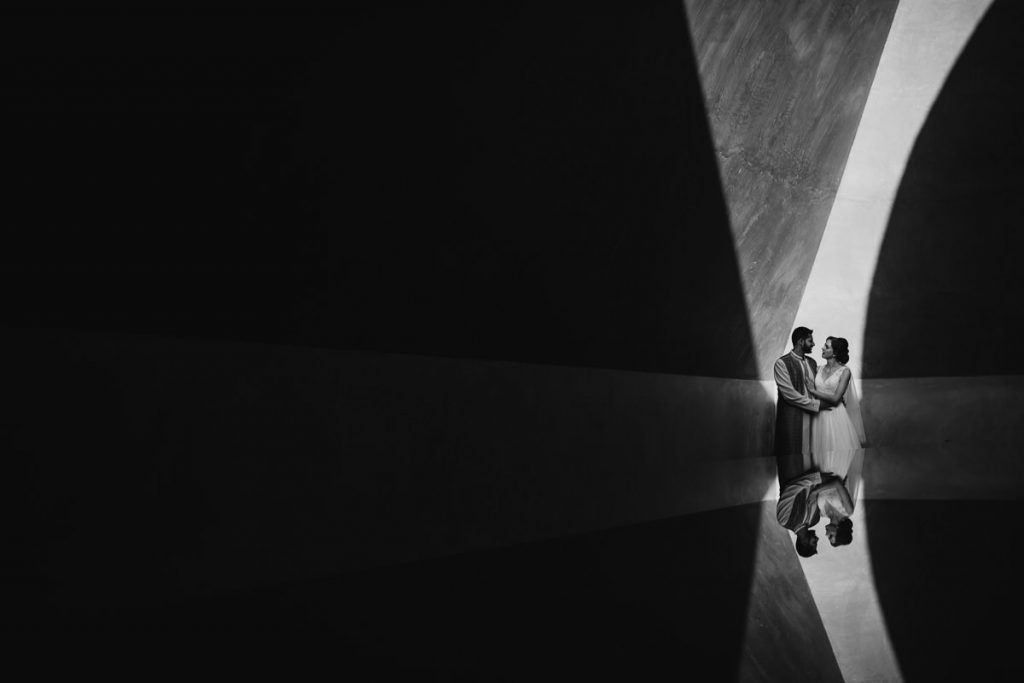 Creative black and white wedding portrait of bride and groom with a reflection in the bottom-half of the image