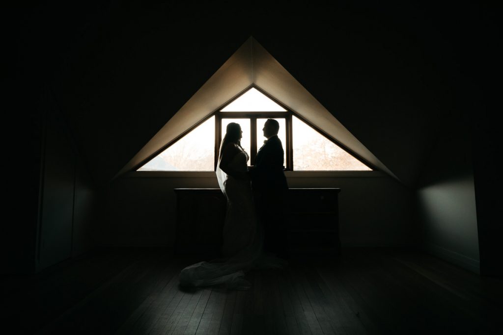 Centennial Vineyards Bowral wedding photographer, Silhouette of bride and groom infront of a triangular window
