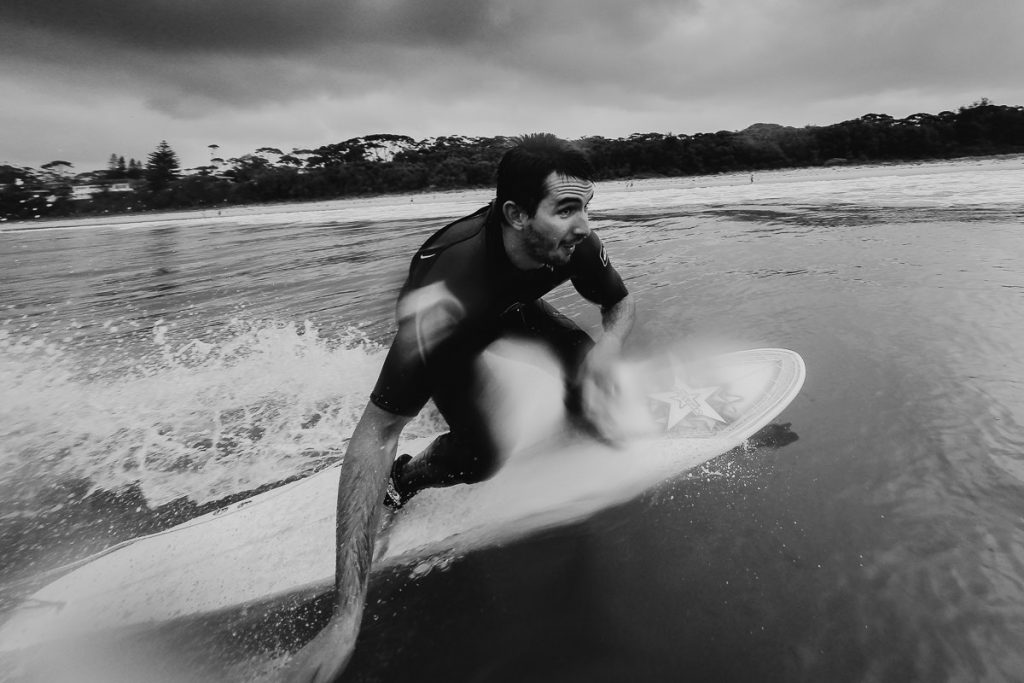 Groom comes in to catch a wave while surfing before his Cupitts Winery Wedding