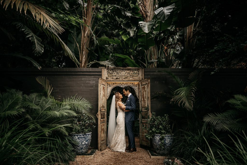 Bride and groom look at each other lovingly in the ornate dorrway at their Jaspers Berry wedding; South Coast Wedding Photographer