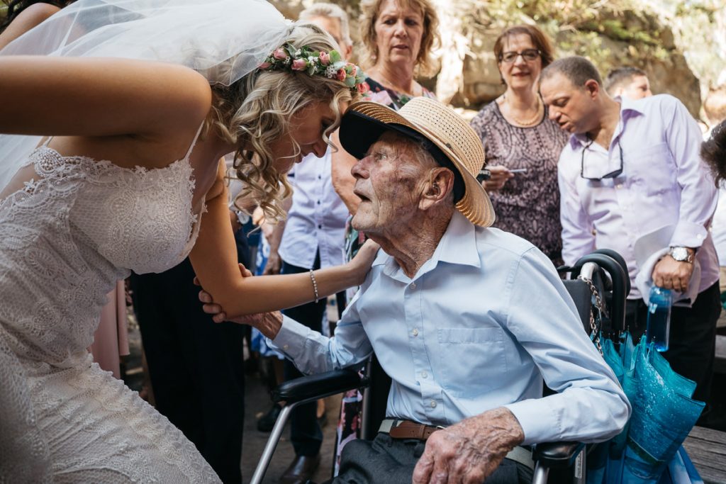 Bride leans over to chat to her grandfather at her Kangaroo Valley Bush Retreat wedding