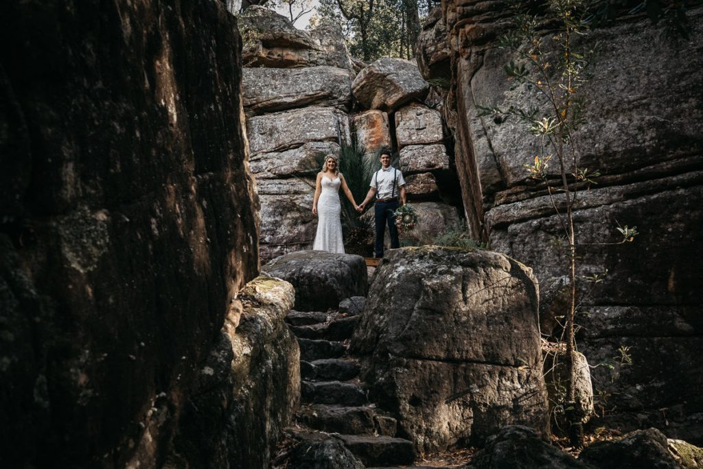 Wedding photographer; Bride and Groom pose amongst the rocks at their Kangaroo Valley Bush Retreat Wedding
