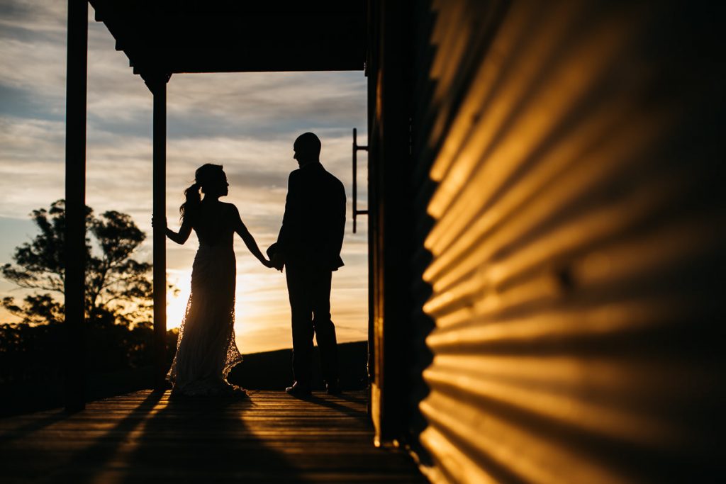 Sunset silhouette of bride and groom on the veranda at their Marlie Brae Wedding; Wedding Photographer Southern Highlands