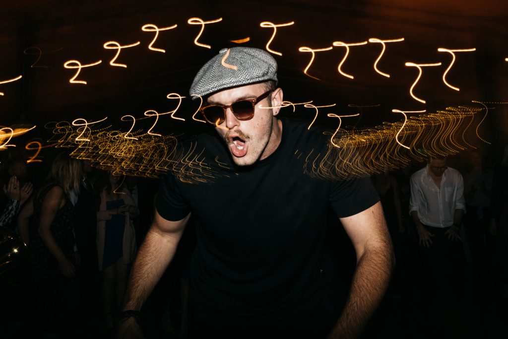 Wedding guest dances and sings between blurring lights; Melross Kangaroo Valley Wedding Photography