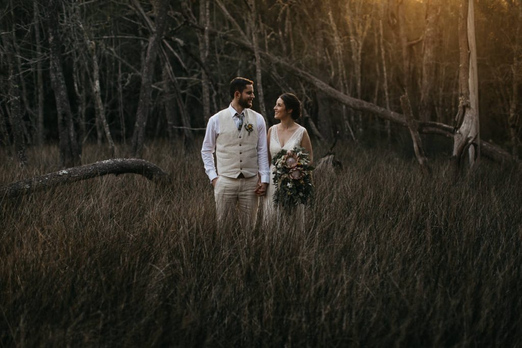 Bride and groom lovingly look at each other while walking outdoors at Paperbark Camp; South Coast Wedding Photography