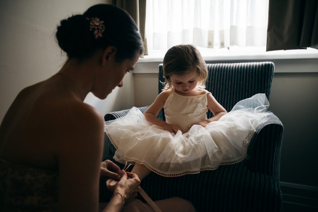 Bride ties the elastics on her little flower girl's shoe; Peppers Wedding Photographer Southern Highlands
