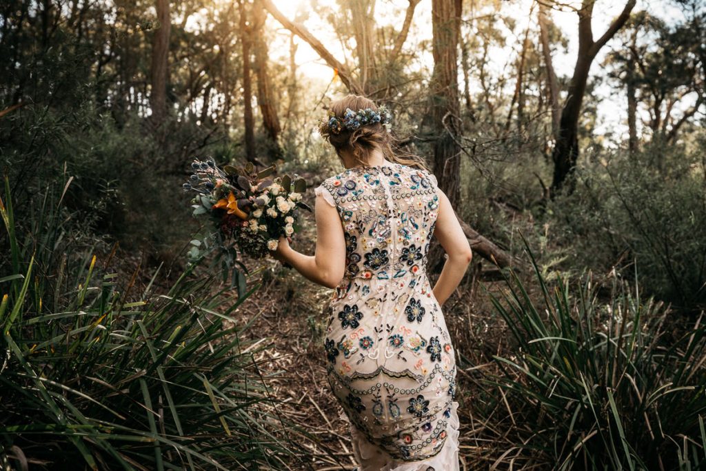 Portrait of a bride walking through the forest in her floral wedding dress in Bowral on the Southern Highlands