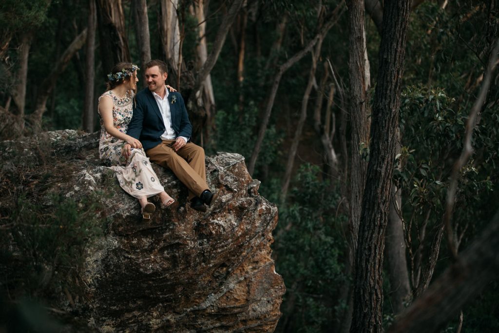 Wedding couple sit on a huge rock at their Bowral Wedding; Southern Highlands Wedding Photographer
