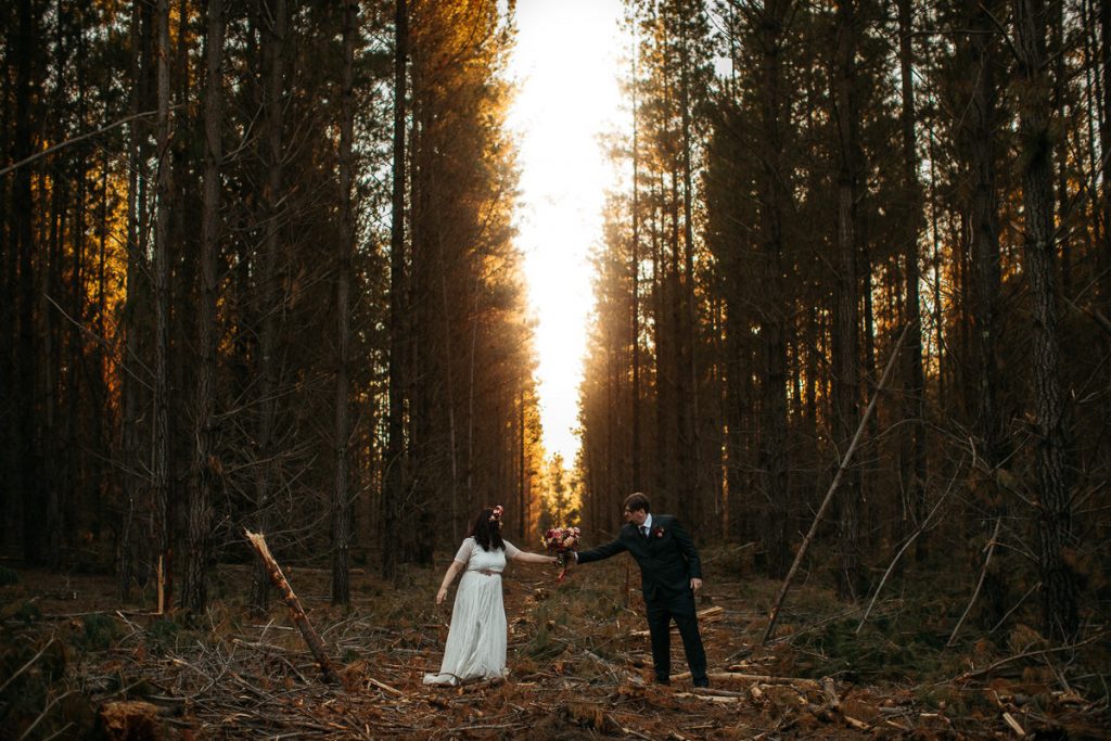 Bride hands her groom the bouquet in the forest in the Southern Highlands