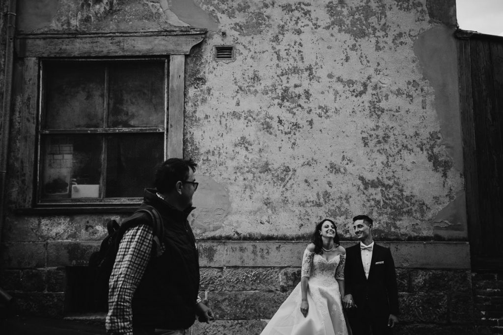 Bride laughs as tourist passes her by; Black and white image; Sydney Wedding Photographer