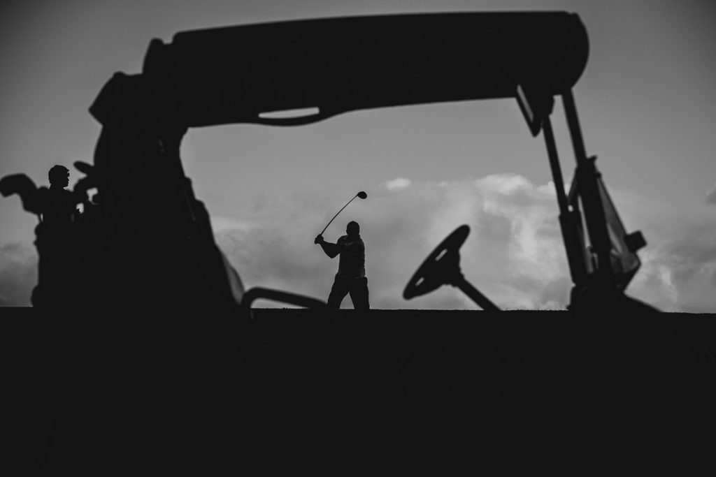 Black and white silhouette of a golf cart and the groom playing golf on the morning of his wedding; Maui Kaanapali Wedding Photographer