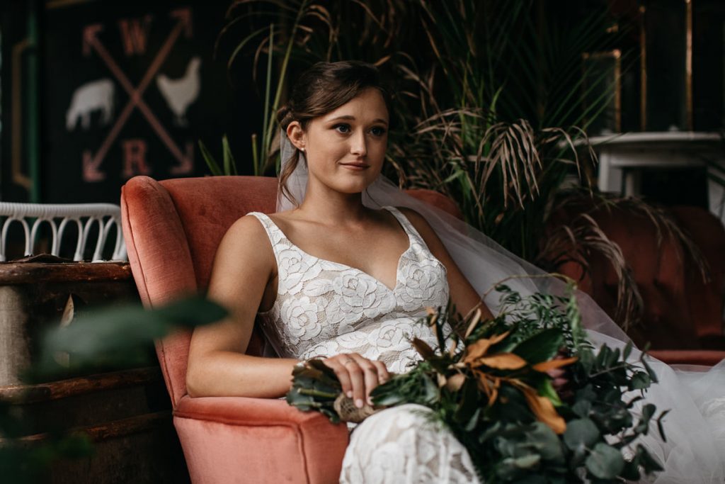 Portrait of a happy bride sitting with her bouquet at her Woods Farm Wedding - South Coast Wedding Photographer